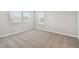 Spacious bedroom with neutral carpet and natural light from a bank of windows at 38190 Shale Stone Ct, Zephyrhills, FL 33540