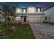 Charming two-story home boasting a stone facade, well-manicured lawn, and paver driveway at 38190 Shale Stone Ct, Zephyrhills, FL 33540