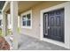 Elegant front door with sidelight, framed by white trim and stone-accented columns at 38190 Shale Stone Ct, Zephyrhills, FL 33540