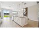 Modern kitchen with a central island, pendant lighting, and sliding glass doors to the yard at 38190 Shale Stone Ct, Zephyrhills, FL 33540