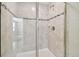 Modern glass-enclosed shower featuring neutral tile and decorative accents at 38190 Shale Stone Ct, Zephyrhills, FL 33540