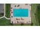 Aerial view of a rectangular community swimming pool with lounge chairs and umbrellas, providing a perfect place for relaxation at 38190 Shale Stone Ct, Zephyrhills, FL 33540