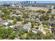 Aerial view featuring a home nestled among lush trees with the city skyline and water views in the distance at 411 W Frances Ave # 2, Tampa, FL 33602