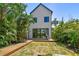 Inviting backyard with a well-manicured lawn, beautiful tropical plants, and a spacious wood deck with outdoor seating at 411 W Frances Ave # 2, Tampa, FL 33602