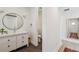 Bathroom with a vanity, round mirror, and doorway to the toilet area at 411 W Frances Ave # 2, Tampa, FL 33602