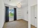 Bright bedroom featuring a window with dark curtains, carpeted floors, and a modern light fixture at 411 W Frances Ave # 2, Tampa, FL 33602