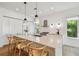 Bright kitchen boasts a marble island with seating, stainless steel appliances, and minimalist white cabinetry at 411 W Frances Ave # 2, Tampa, FL 33602