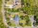 Overhead view of a home with a private pool surrounded by a lush lawn and tree-lined property at 4180 Jacaranda Cir, Brooksville, FL 34604