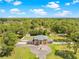 Aerial view of the home showing lush trees and a fountain in a circular driveway at 4180 Jacaranda Cir, Brooksville, FL 34604
