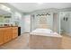Bathroom featuring a large soaking tub, tiled floors, and light green walls at 4180 Jacaranda Cir, Brooksville, FL 34604