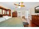 Well-lit bedroom with hardwood floors, ceiling fan, and wooden furniture at 4180 Jacaranda Cir, Brooksville, FL 34604