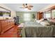 Spacious bedroom with a TV, treadmill, and a cozy seating area by the window at 4180 Jacaranda Cir, Brooksville, FL 34604