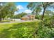 Beautiful two-story home with a well-maintained lawn surrounded by lush greenery and a white fence at 4180 Jacaranda Cir, Brooksville, FL 34604