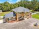 Elegant two-story home featuring decorative columns, mature landscaping, and circular driveway with a fountain at 4180 Jacaranda Cir, Brooksville, FL 34604