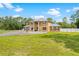 Spacious front yard view of the stately home showcasing its well-manicured lawn and circular driveway at 4180 Jacaranda Cir, Brooksville, FL 34604