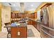 Spacious kitchen features stainless steel appliances, island with cooktop, and wooden cabinetry at 4180 Jacaranda Cir, Brooksville, FL 34604