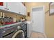Well-lit laundry room with white cabinets and modern appliances at 4180 Jacaranda Cir, Brooksville, FL 34604