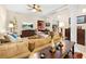 A cozy living room with plush sofas, decorative lamps, a ceiling fan, and a view of the hallway at 4180 Jacaranda Cir, Brooksville, FL 34604