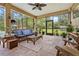 A screened-in patio featuring comfortable wicker furniture, ideal for relaxation and enjoying views of the pool and garden at 4180 Jacaranda Cir, Brooksville, FL 34604
