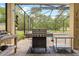Enjoy outdoor cooking with a built-in grill in this screened patio, overlooking a serene swimming pool at 4180 Jacaranda Cir, Brooksville, FL 34604
