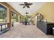 A covered patio featuring brick flooring, ceiling fans, and an outdoor dining set, perfect for entertaining guests at 4180 Jacaranda Cir, Brooksville, FL 34604