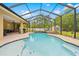 Serene screened-in pool area with sun loungers, complemented by the patio, creates a perfect spot for relaxation and entertainment at 4180 Jacaranda Cir, Brooksville, FL 34604