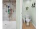 Shower with two shower heads and shower caddy with multiple shampoos and soaps next to a toilet at 4180 Jacaranda Cir, Brooksville, FL 34604