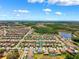 Expansive aerial view of the community featuring many homes, surrounding trees, and a scenic lake at 4275 Burdick Loop, Odessa, FL 33556
