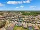 Wide aerial view of the community highlighting homes, green spaces, and nearby lakes at 4275 Burdick Loop, Odessa, FL 33556