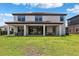 Backyard view of the home, showing a covered patio and lawn at 4275 Burdick Loop, Odessa, FL 33556