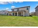 Backyard view of the home, showing the covered patio and ample lawn space at 4275 Burdick Loop, Odessa, FL 33556