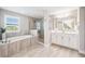 Elegant bathroom with a soaking tub, glass shower, and double vanity at 4275 Burdick Loop, Odessa, FL 33556