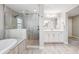 Stylish bathroom featuring a soaking tub, walk-in shower, and a white double vanity at 4275 Burdick Loop, Odessa, FL 33556