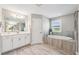 Luxurious bathroom with double vanity, soaking tub, and a glass enclosed shower at 4275 Burdick Loop, Odessa, FL 33556
