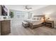 Comfortable bedroom with a wooden bed frame, plush carpeting, and three bright windows at 4275 Burdick Loop, Odessa, FL 33556