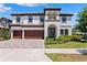 Stunning two-story home showcasing a 3-car garage and tile roof in a beautifully landscaped setting at 4275 Burdick Loop, Odessa, FL 33556