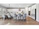Bright kitchen boasts white cabinetry, stainless steel appliances, an island with seating, and a modern lighting fixture at 4275 Burdick Loop, Odessa, FL 33556