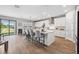 Modern kitchen with white cabinets, stainless steel appliances, an island with bar seating, and sliding glass doors at 4275 Burdick Loop, Odessa, FL 33556
