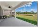 Relaxing covered patio with outdoor seating and beautiful view of the yard and pond at 4275 Burdick Loop, Odessa, FL 33556