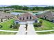 Stunning aerial view of the home with a pond, pristine landscaping, and an elongated brick driveway at 4300 Barletta Ct, Wesley Chapel, FL 33543