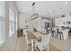 Cozy dining area featuring a rustic wood table with white chairs and a modern light fixture at 4300 Barletta Ct, Wesley Chapel, FL 33543