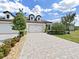 Attractive home with a three-car garage and beautiful brick driveway, framed by meticulously maintained landscaping at 4300 Barletta Ct, Wesley Chapel, FL 33543