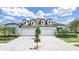 Beautiful single-story home with a three-car garage, a well-manicured lawn, and a charming brick driveway at 4300 Barletta Ct, Wesley Chapel, FL 33543