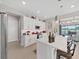 White kitchen with a center island, stainless steel appliances, and views of the living room and patio at 4300 Barletta Ct, Wesley Chapel, FL 33543
