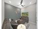 Cozy living room features a ceiling fan, comfortable gray sectional sofa and ottoman at 4300 Barletta Ct, Wesley Chapel, FL 33543