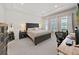 Spacious main bedroom features a king bed, tray ceiling, brick accent wall and abundant natural light at 4300 Barletta Ct, Wesley Chapel, FL 33543