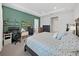 Expansive main bedroom with a work area, king bed, brick accent wall and tray ceiling at 4300 Barletta Ct, Wesley Chapel, FL 33543