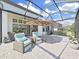 Charming screened-in patio featuring stylish seating, outdoor dining area, and peaceful backyard scenery at 4300 Barletta Ct, Wesley Chapel, FL 33543