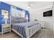 Cozy bedroom showcasing a queen bed, white furniture, and blue accent wall at 445 Hamden Dr # 502, Clearwater Beach, FL 33767