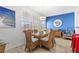 Cozy dining area with a glass table, wicker chairs, and bright blue accent wall at 445 Hamden Dr # 502, Clearwater Beach, FL 33767